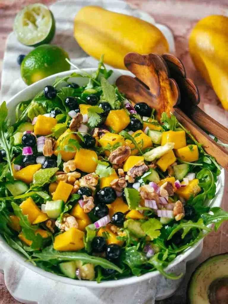 Mango Cucumber Salad with Blueberry and Avocado is served in a ceramic bowl.