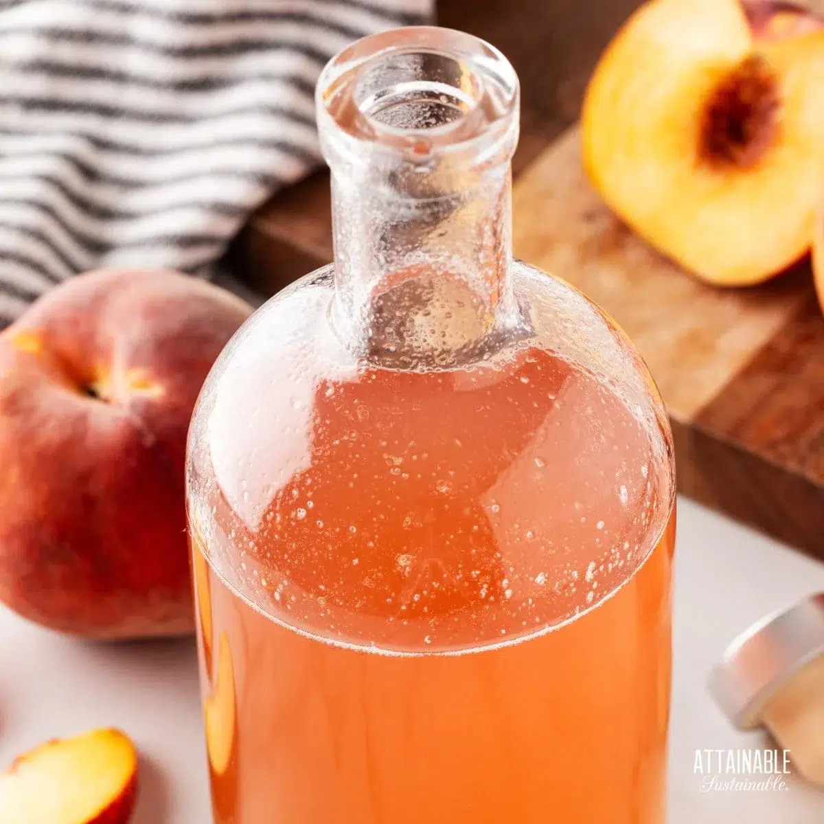 peach syrup in a jar with sliced peach alongside.