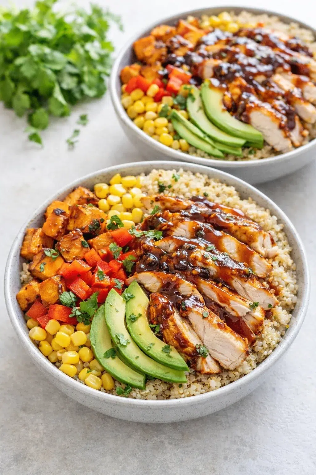 step-process-placeholder-13-16.png Grain bowls filled with quinoa, roasted sweet potatoes, corn, diced red pepper, and avocado slices.
