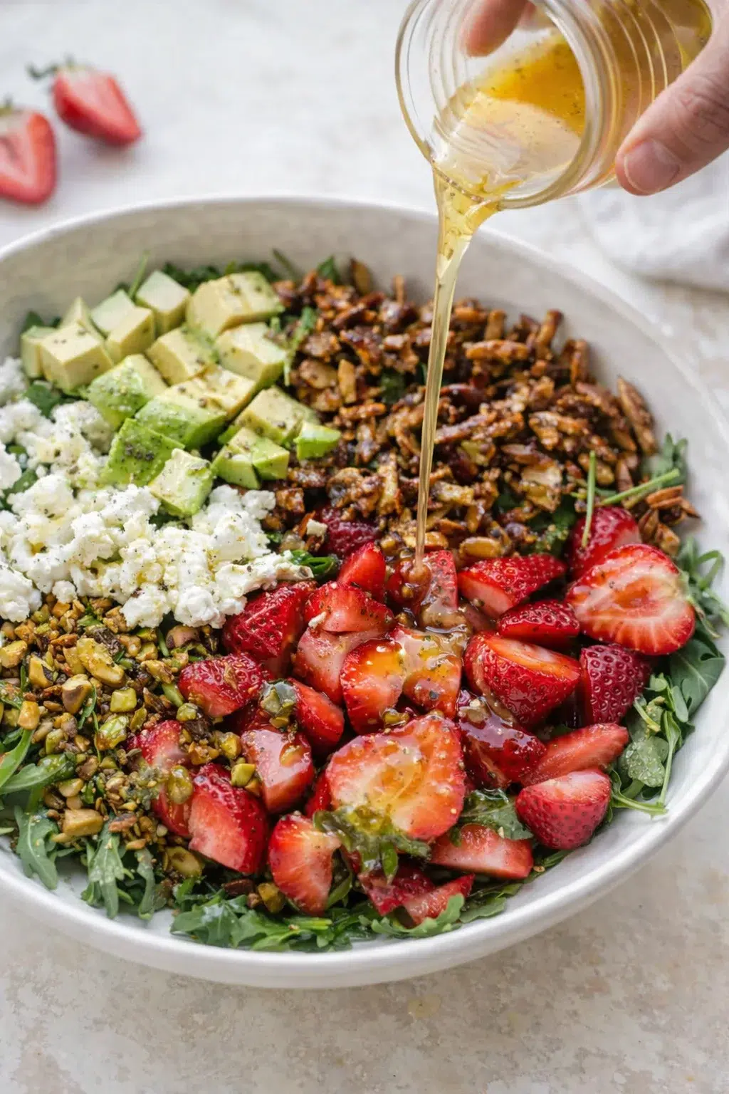 step-process-placeholder-9-12.png Arugula bowl topped with strawberries, avocado chunks, crumbled goat cheese, pistachios, and sugared almonds.
