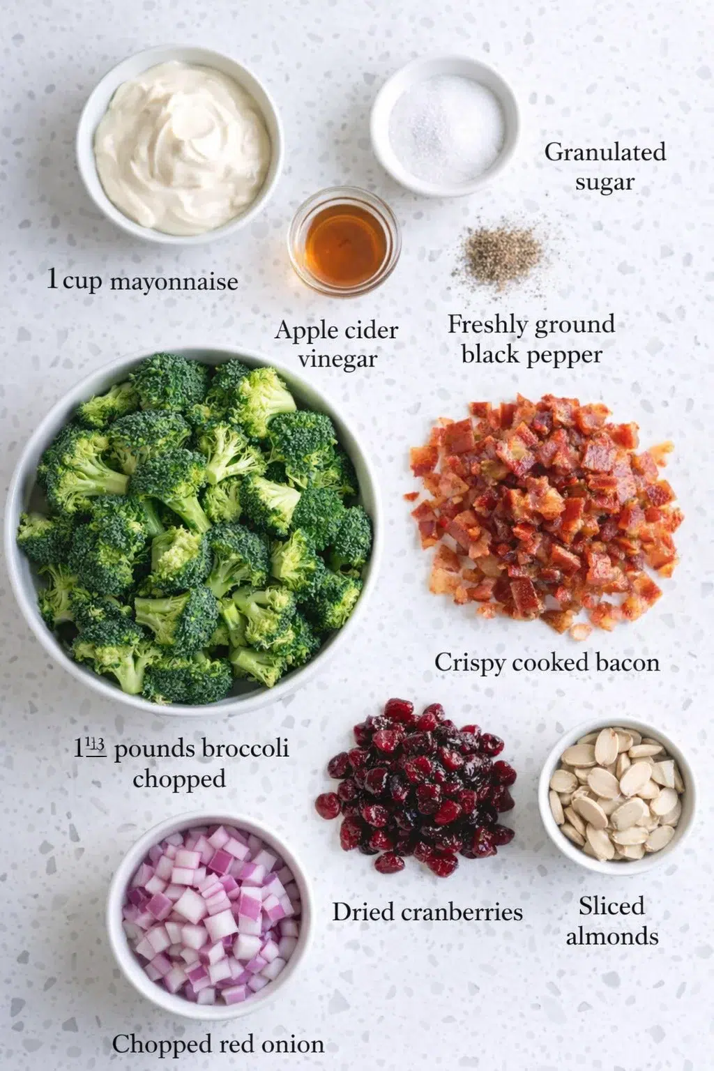 Measured ingredients arranged for Broccoli Salad: 1 cup mayonnaise, 1½ tablespoons granulated sugar, 3 tablespoons apple cider vinegar, ¼ teaspoon freshly ground black pepper, 1⅓ pounds broccoli florets, chopped into bit