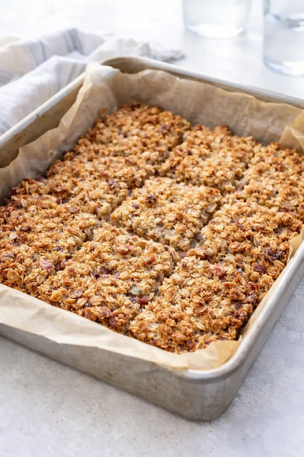 step-process-placeholder-9-10.png Golden-brown oat-topped bars cooling in pan on rack, with foil tenting visible.