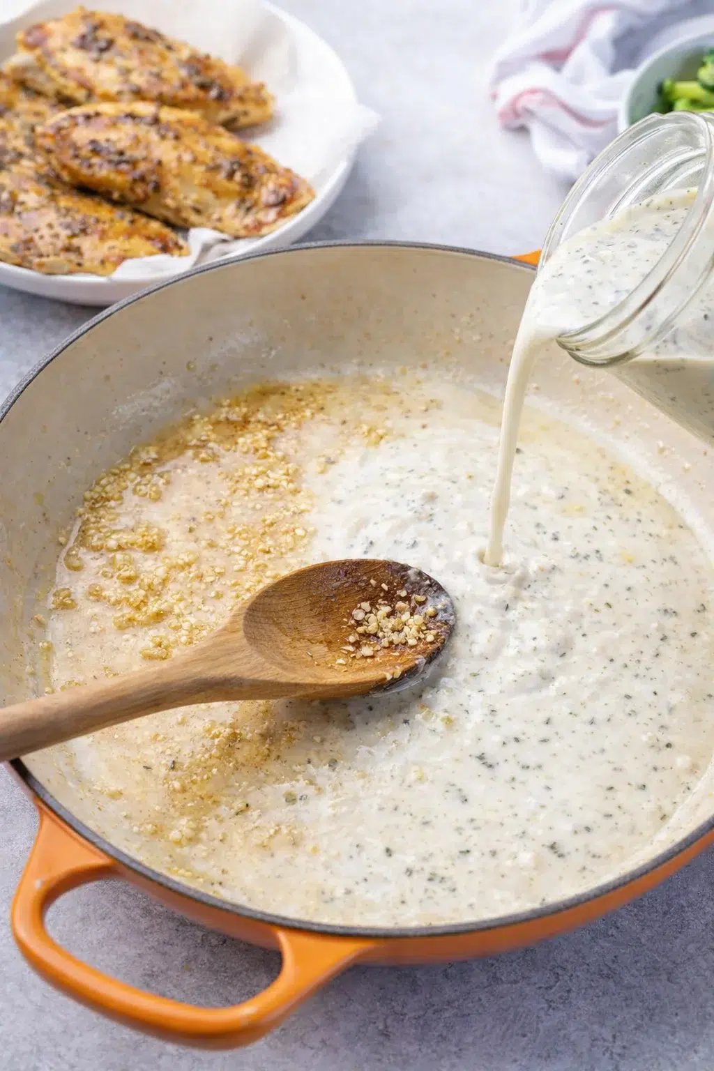 step-process-placeholder-5-8.png Golden-seared chicken removed from skillet while garlic sautés and almond milk mixture simmers, thickening