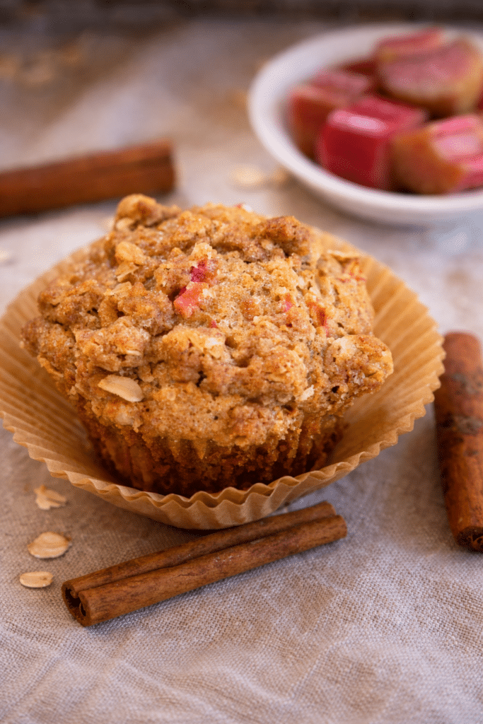 top view of a Rhubarb Oat Muffin with raw pieces of rhubarb in a bowl