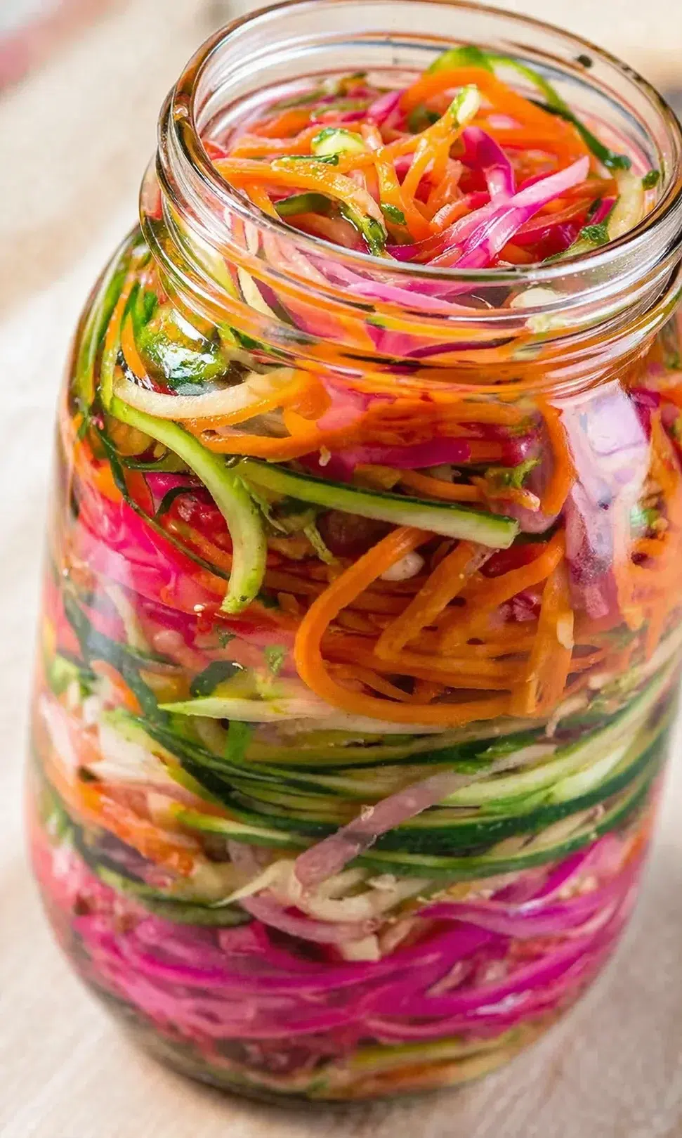 Colorful shredded vegetables layered in a glass mason jar, ready-to-eat slaw.