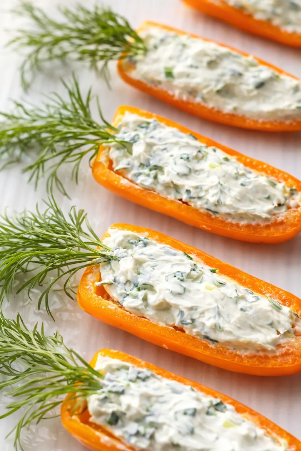orange bell pepper halves filled with creamy herb cheese, garnished with dill