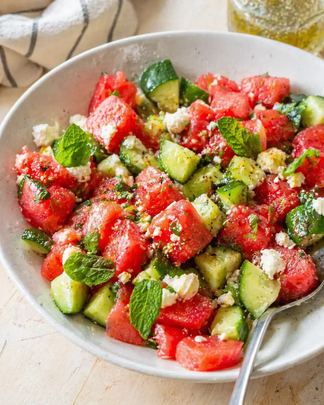 Single plated variation of Watermelon Salad with Feta, Cucumber and Mint | The Mediterranean Dish shown in a natural kitchen scene