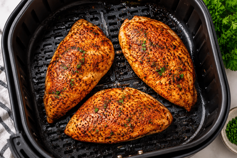 Juicy air fryer boneless chicken breasts seasoned with paprika and herbs on a serving plate