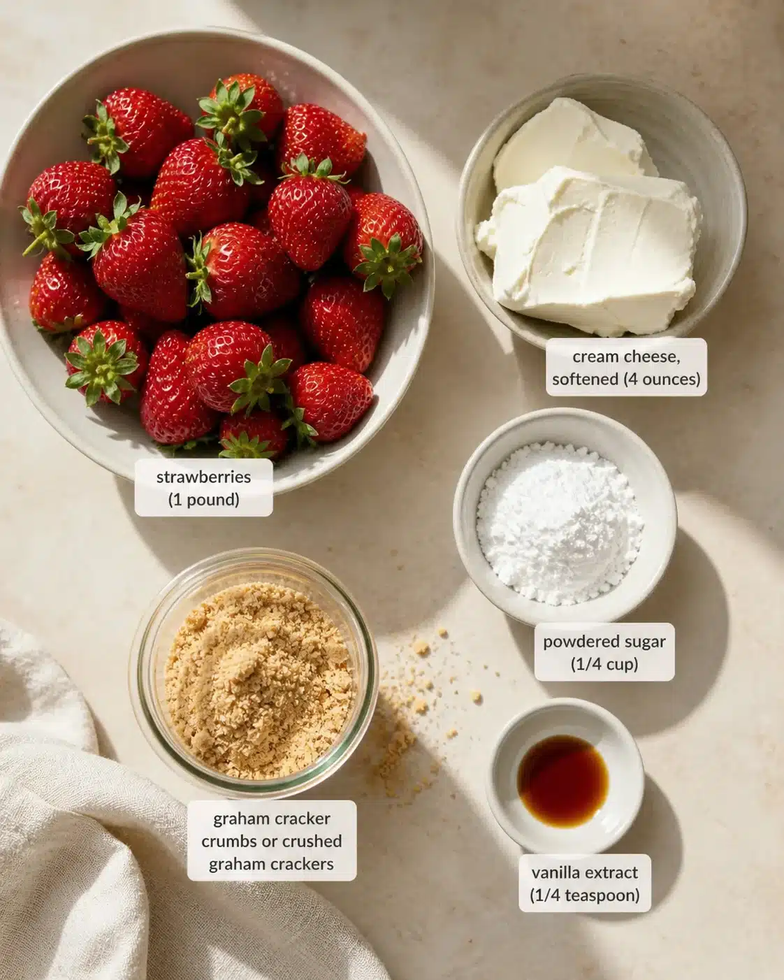 Top-down view of strawberries in a bowl with cream cheese, sugar, and graham crackers.
