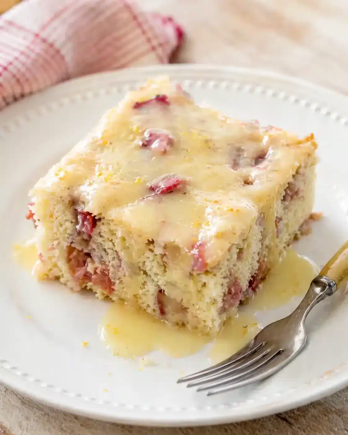 Single plated variation of Rhubarb Cake with Butter Sauce shown in a natural kitchen scene
